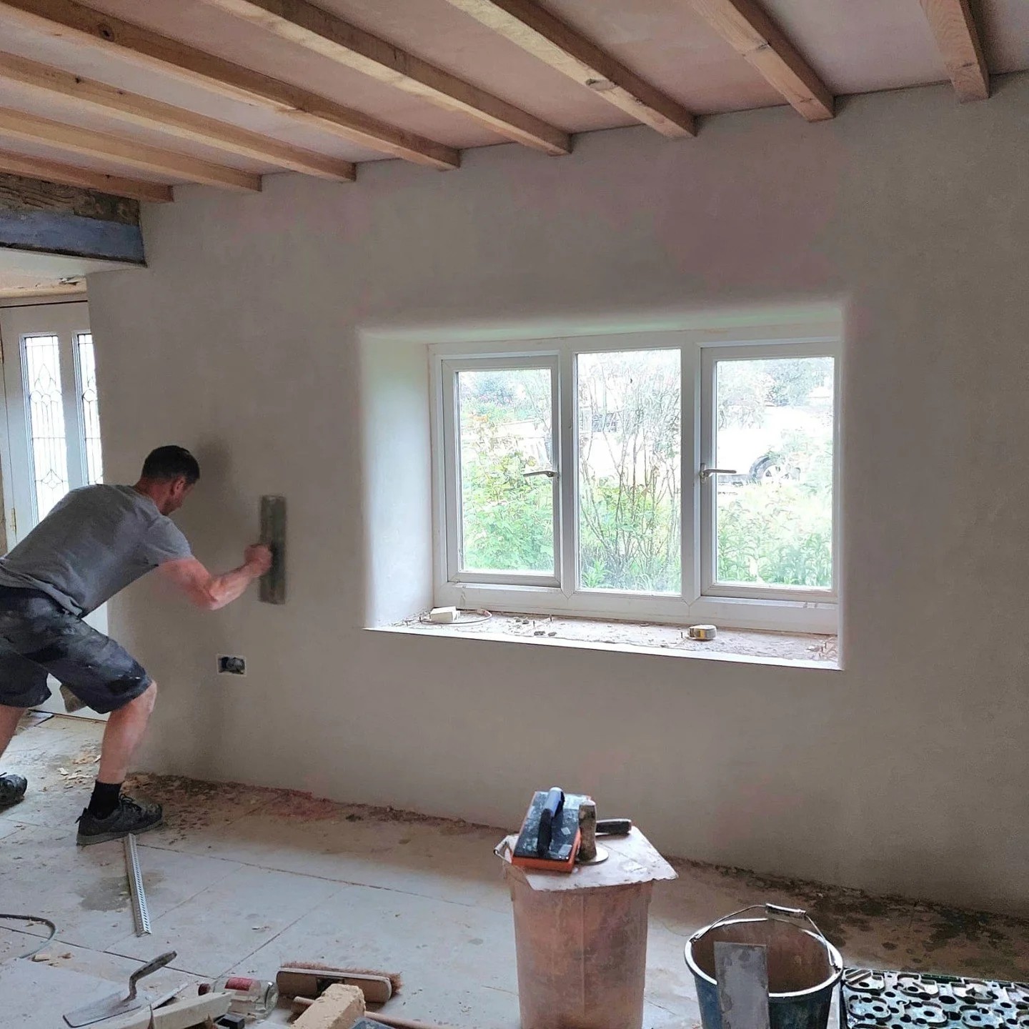 Floating a wall smooth in a beamed cottage room